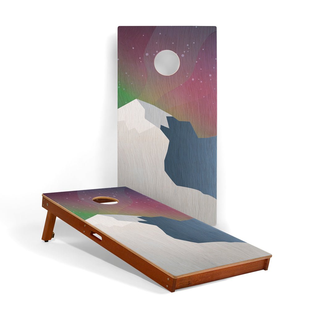 Cornhole board with mountain and moon design on a white background