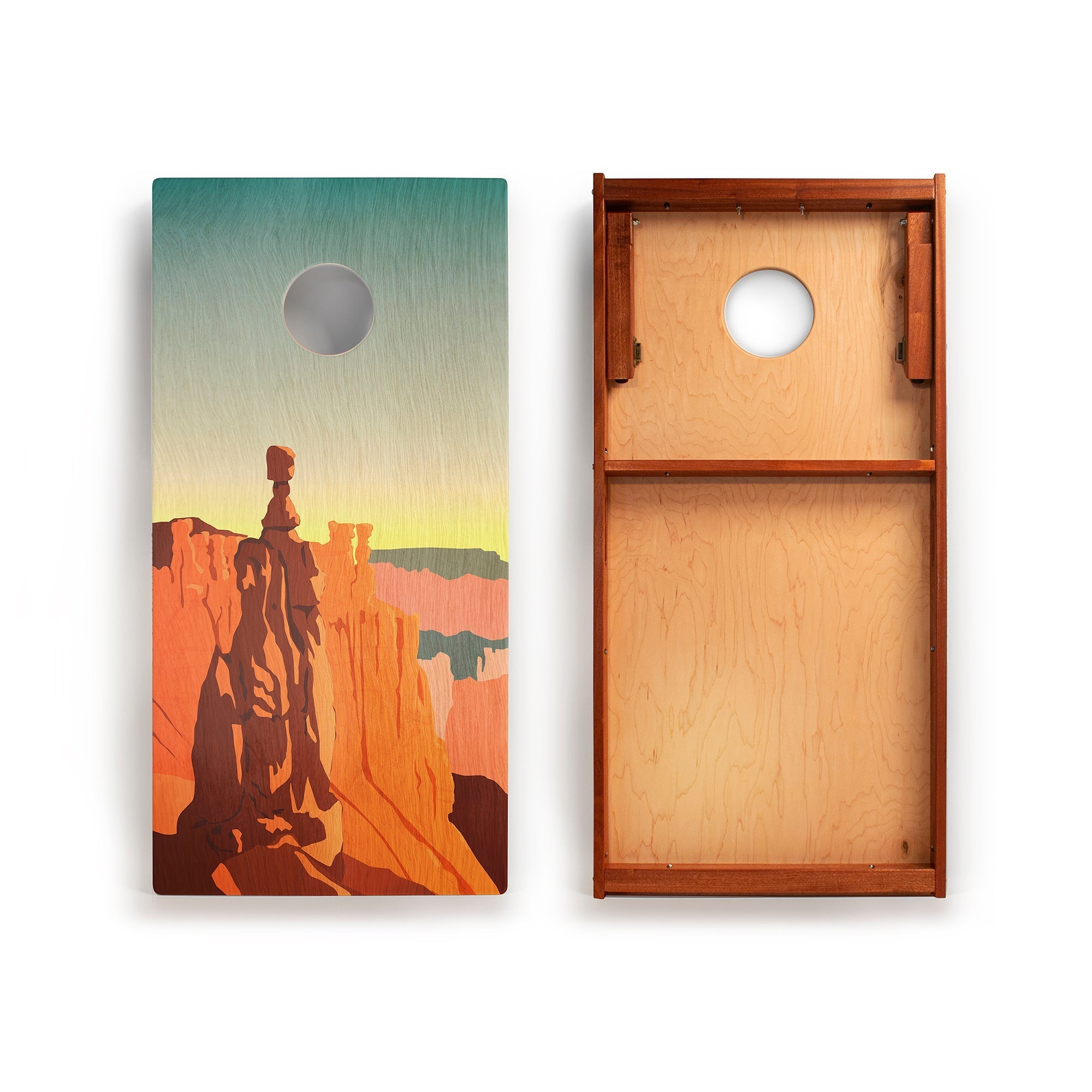 Two cornhole boards with a desert landscape design featuring a silhouette of a person and natural scenery.
