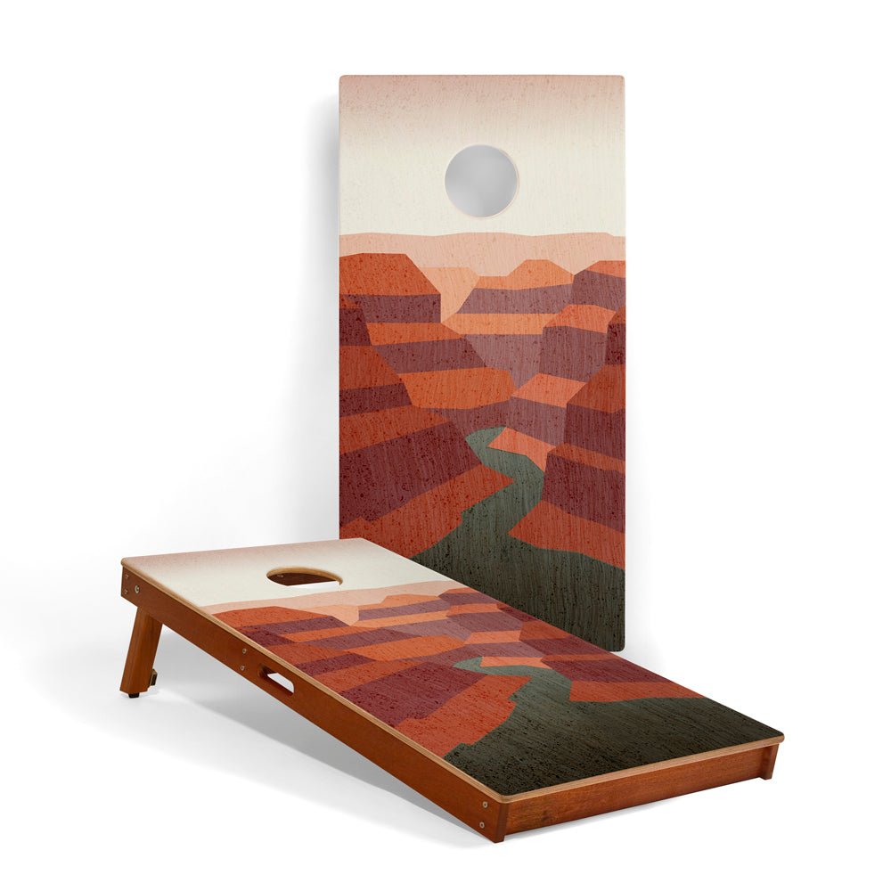 Cornhole board with desert landscape design on a white background