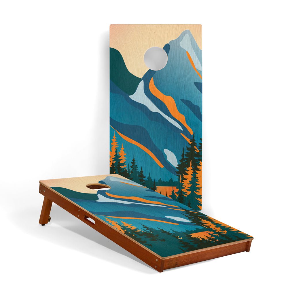 Cornhole board with mountain and forest design on a white background