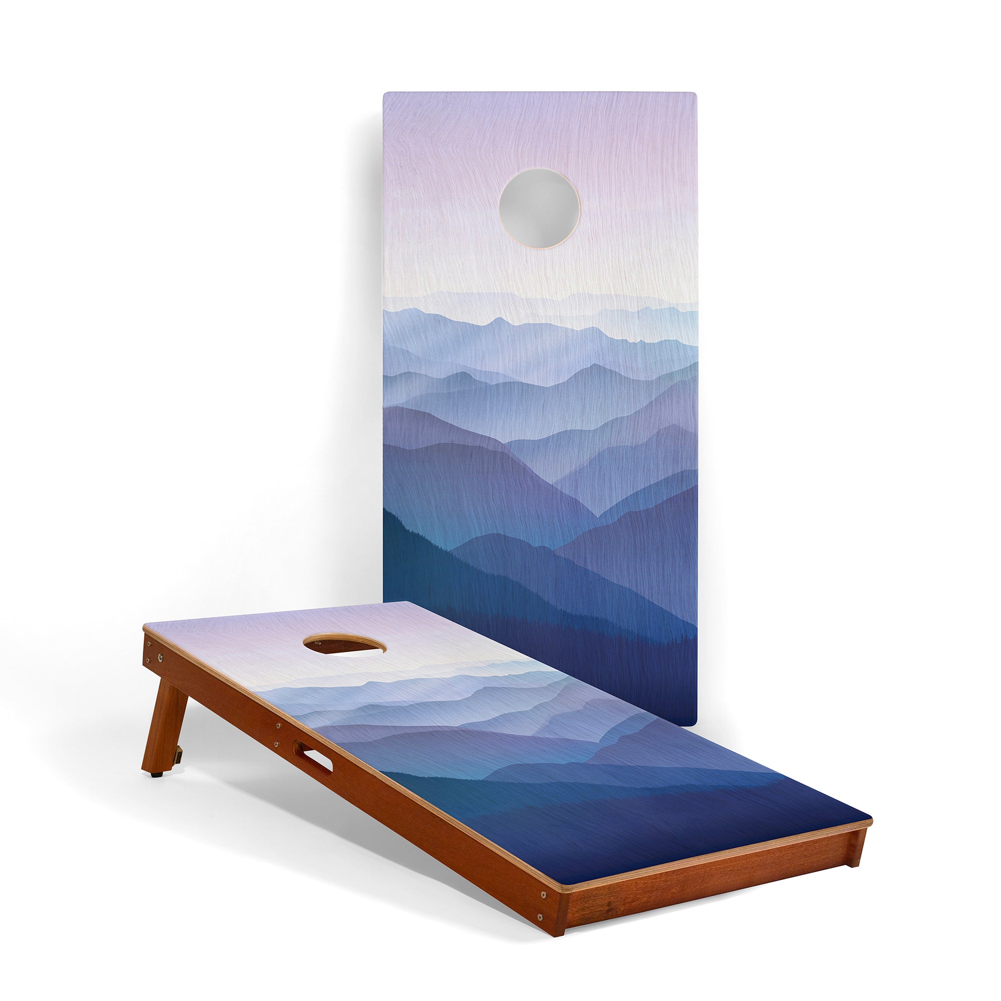 Cornhole board with mountain design on a white background