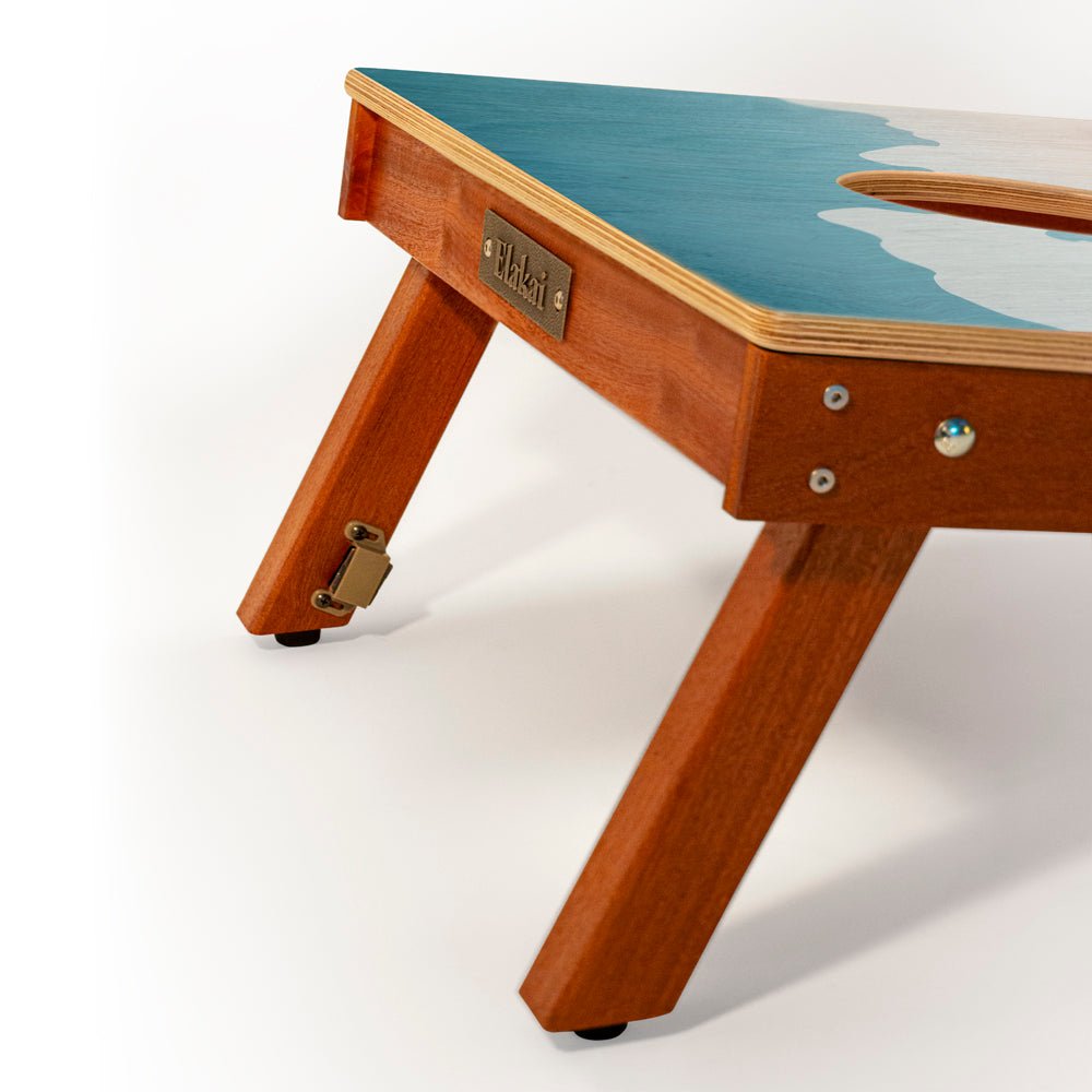 Wooden table with a blue top and visible brand name on a white background