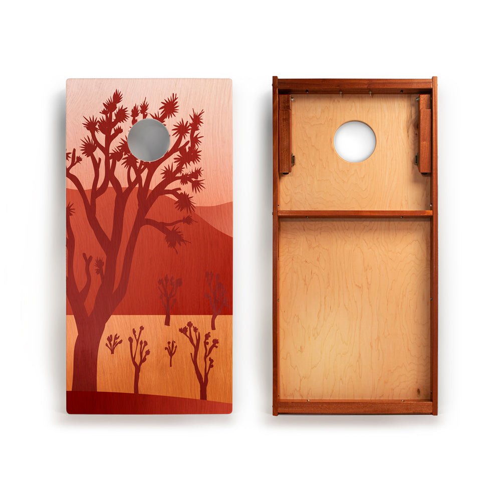 Wooden cornhole board with desert landscape design on one side and plain wood on the other.