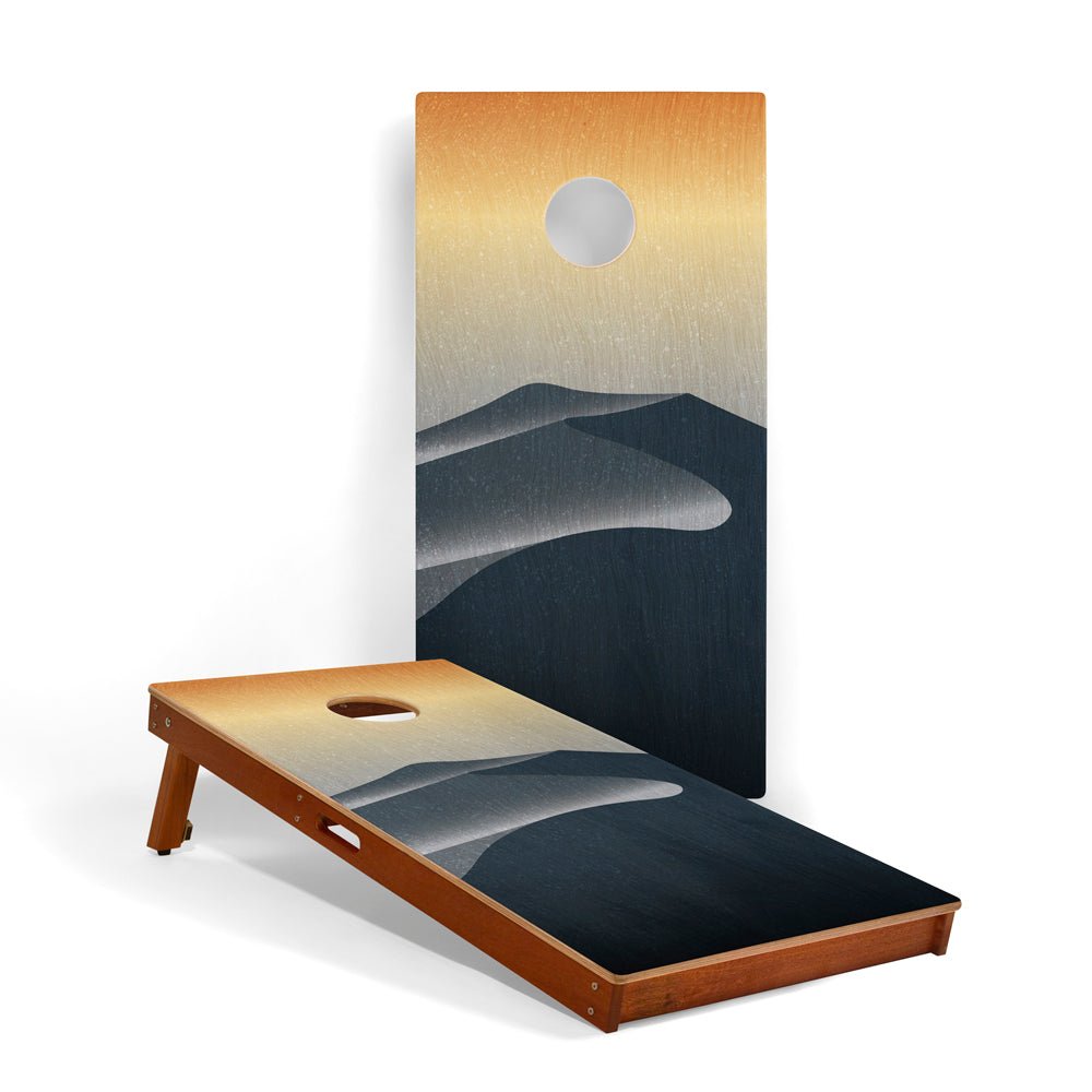 Cornhole board with mountain design against a white background
