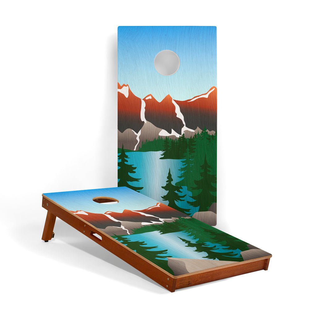 Cornhole board with mountain and lake design on a white background