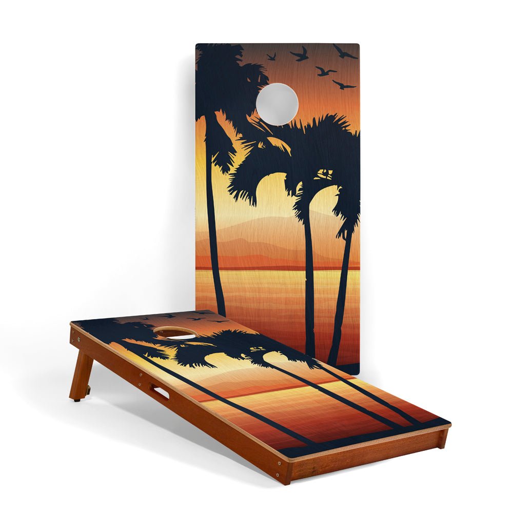 Cornhole board with palm tree and sunset design on a white background