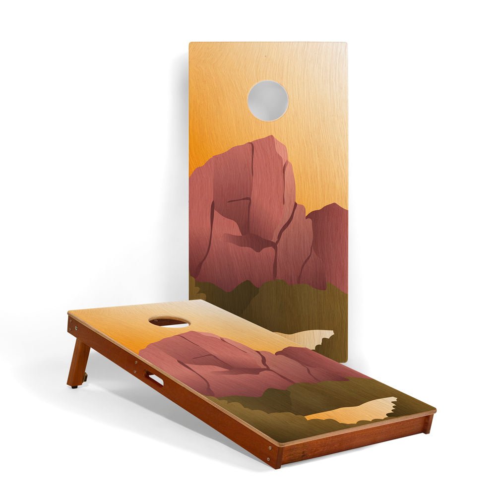 Cornhole board with mountain design on a white background