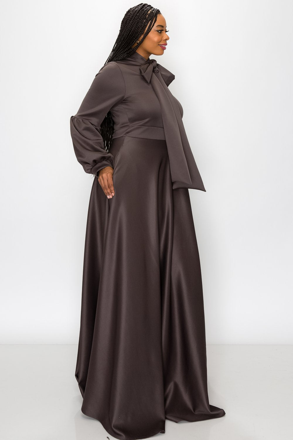 Woman wearing a brown dress with a matching jacket on a white background