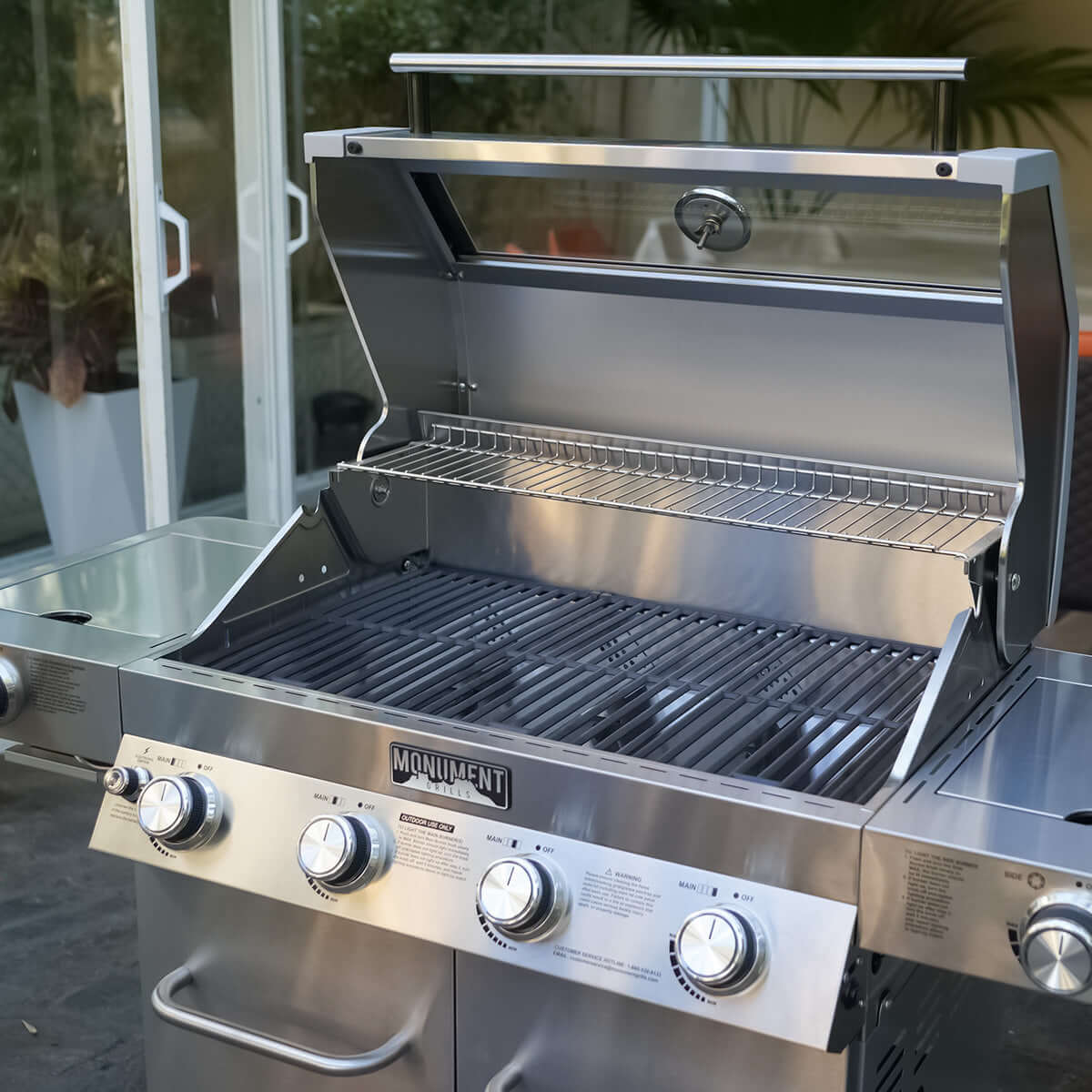 Stainless steel grill with 'Monument' branding on a patio background