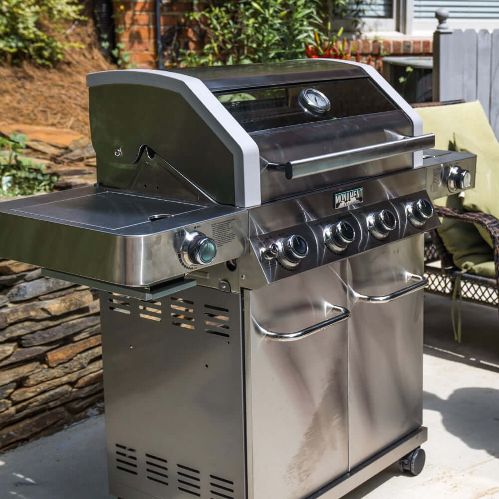 Stainless steel grill on a patio with outdoor setting