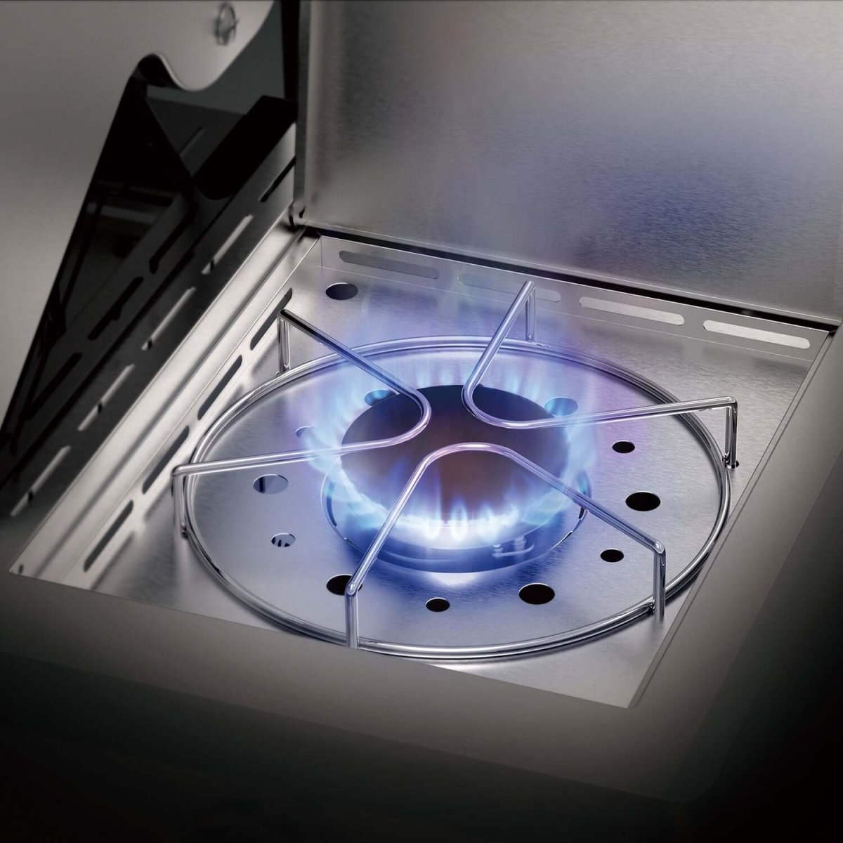 Gas stove burner ignited with blue flame inside a kitchen setting