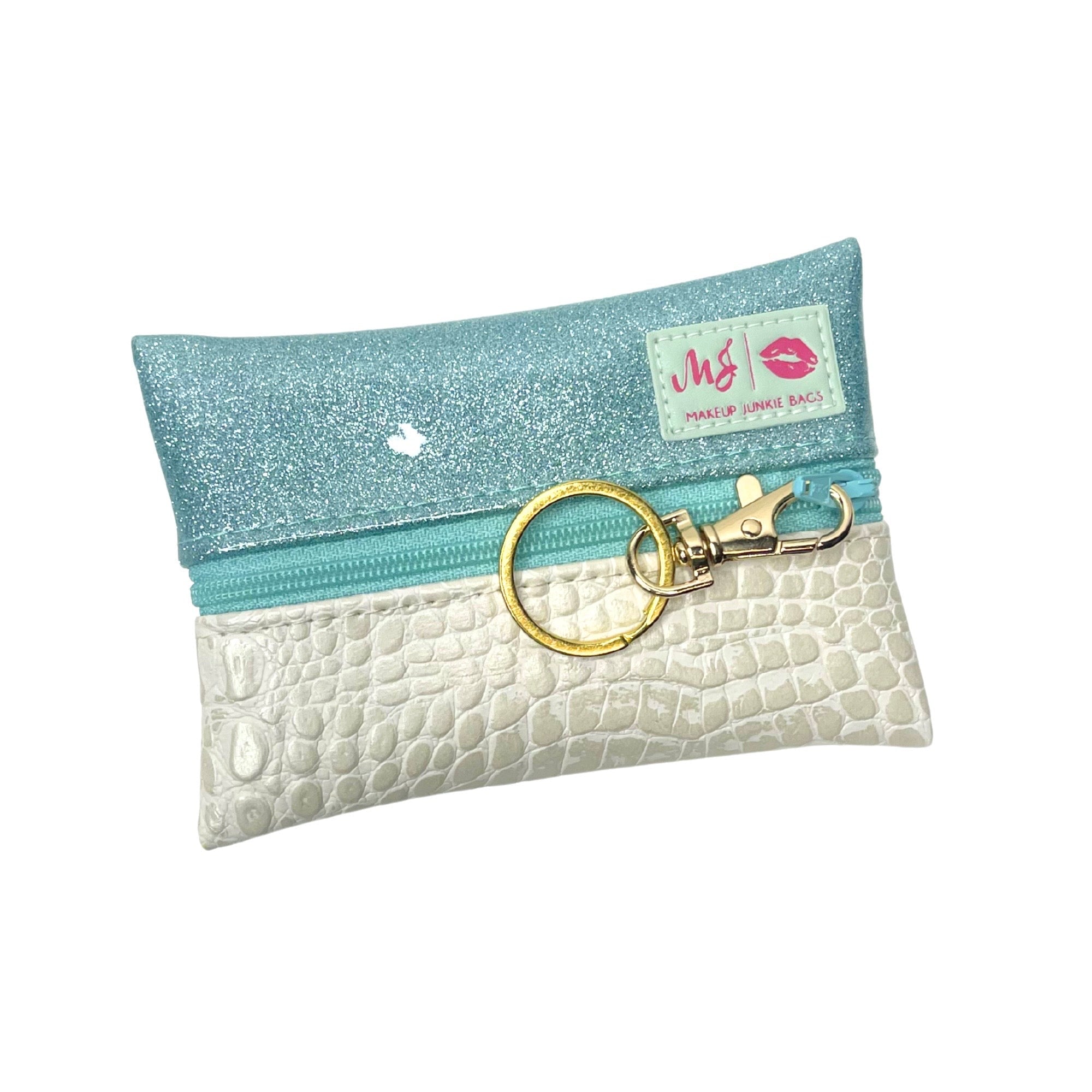 Makeup bag with blue top and white bottom, featuring a keychain, on a white background.