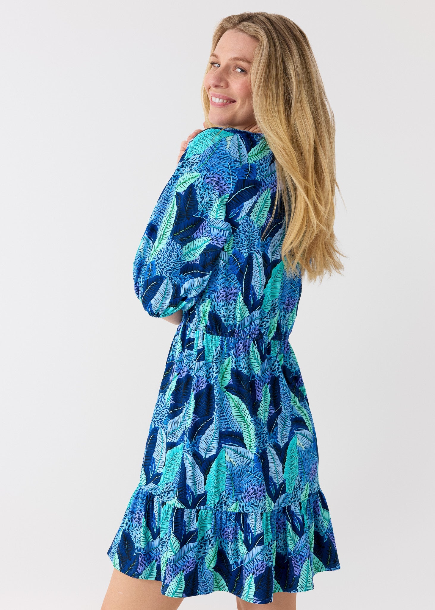 Woman wearing a blue patterned dress on a white background