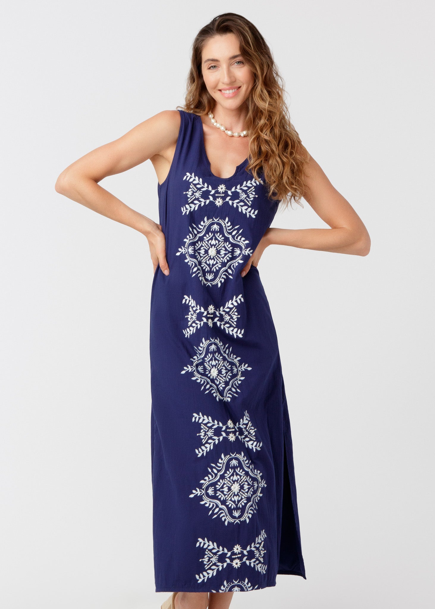 Woman wearing a blue dress with white patterns on a white background