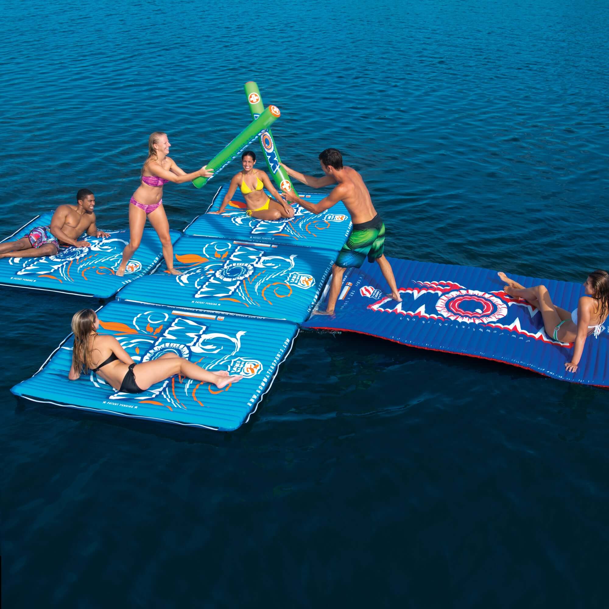 People playing on inflatable water mats in a body of water