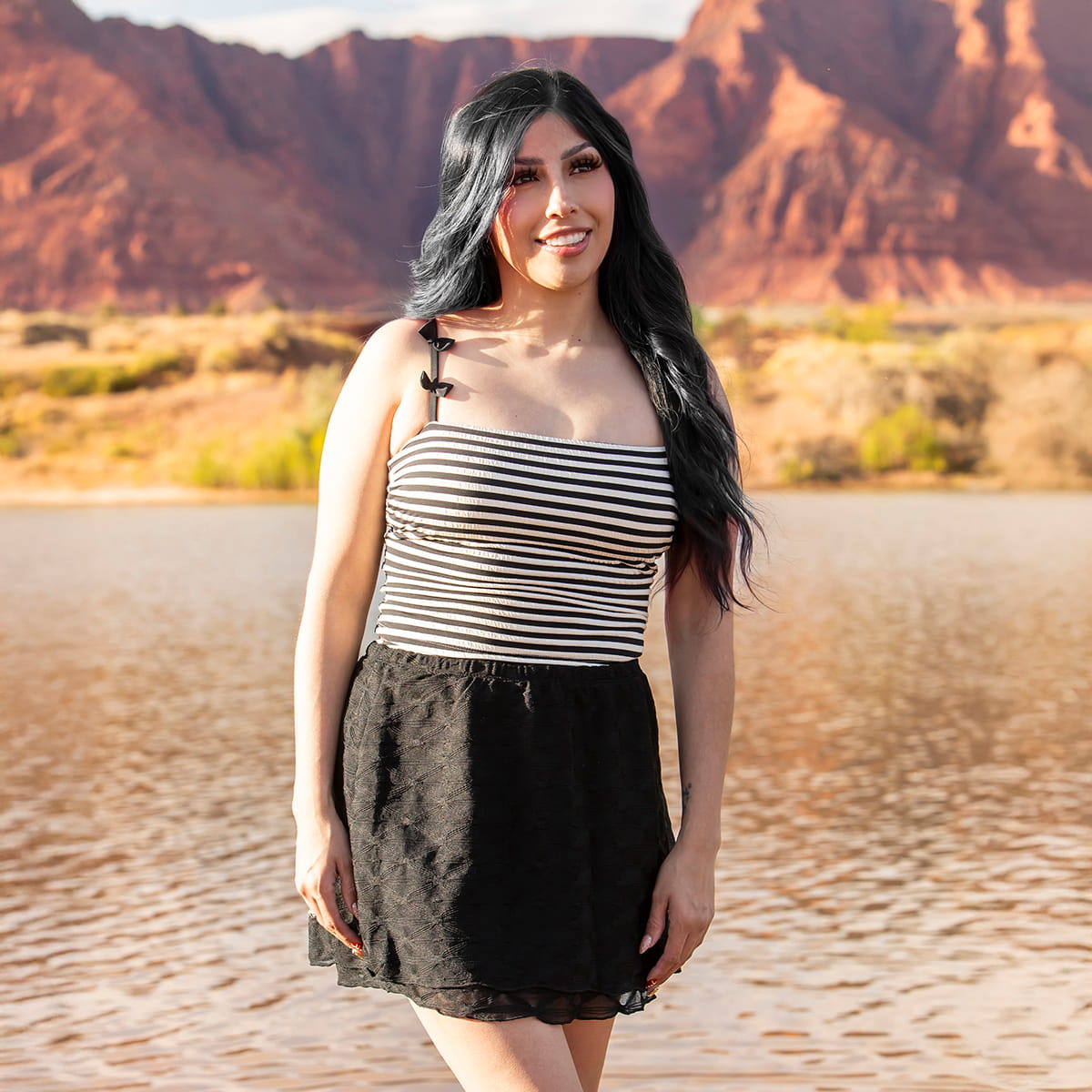 Woman standing in a desert landscape with mountains in the background