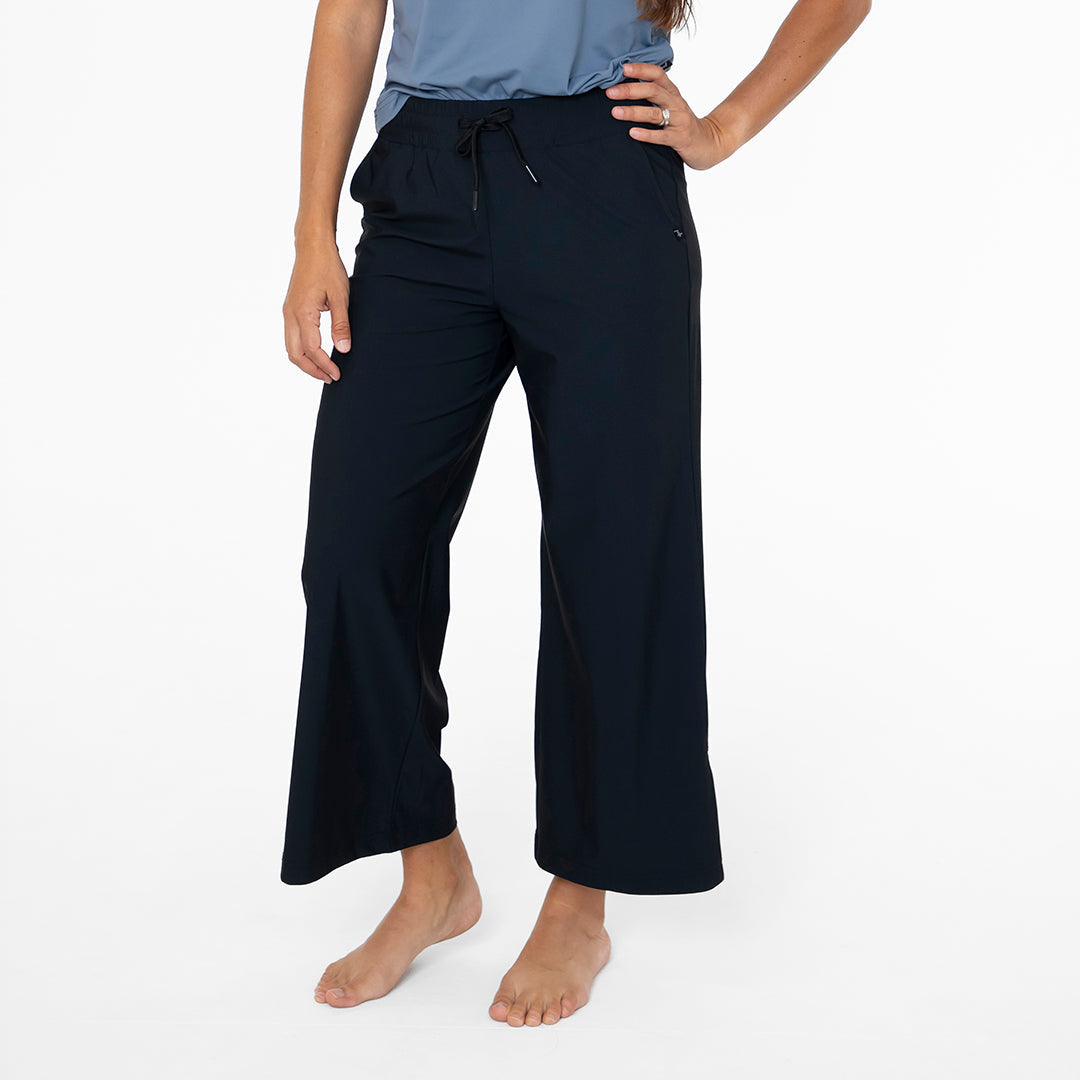 Person wearing navy blue wide-leg pants on a white background