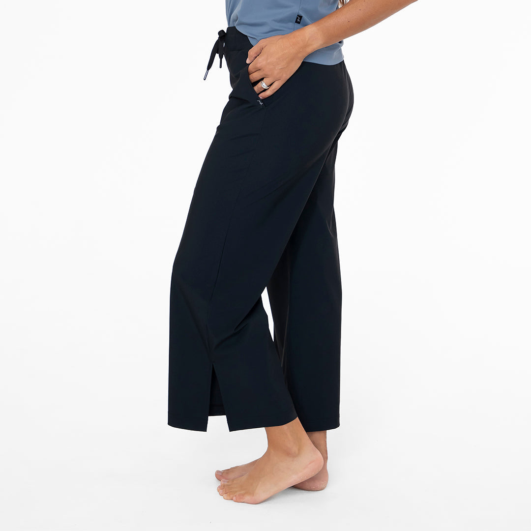Person wearing black wide-leg pants on a white background
