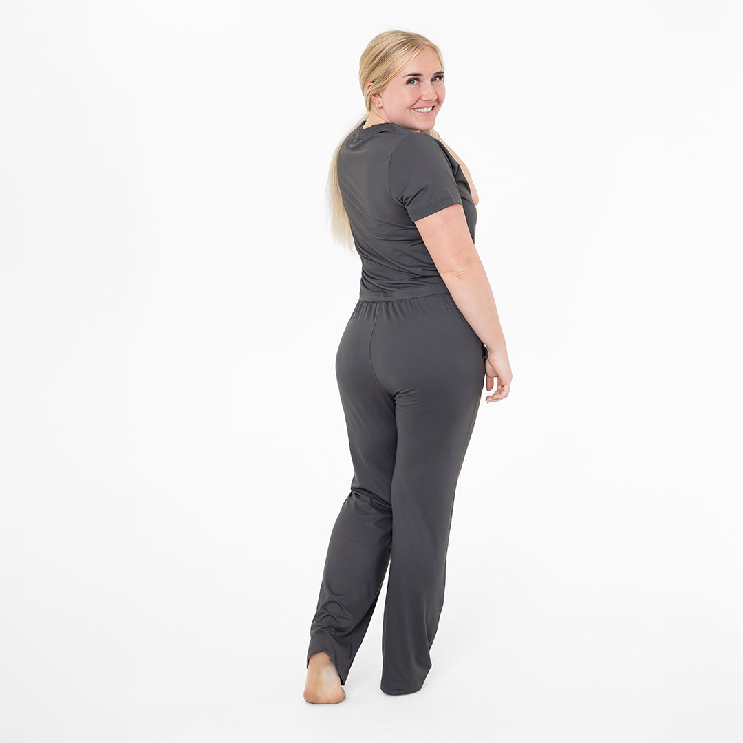 Woman wearing a gray jumpsuit on a white background