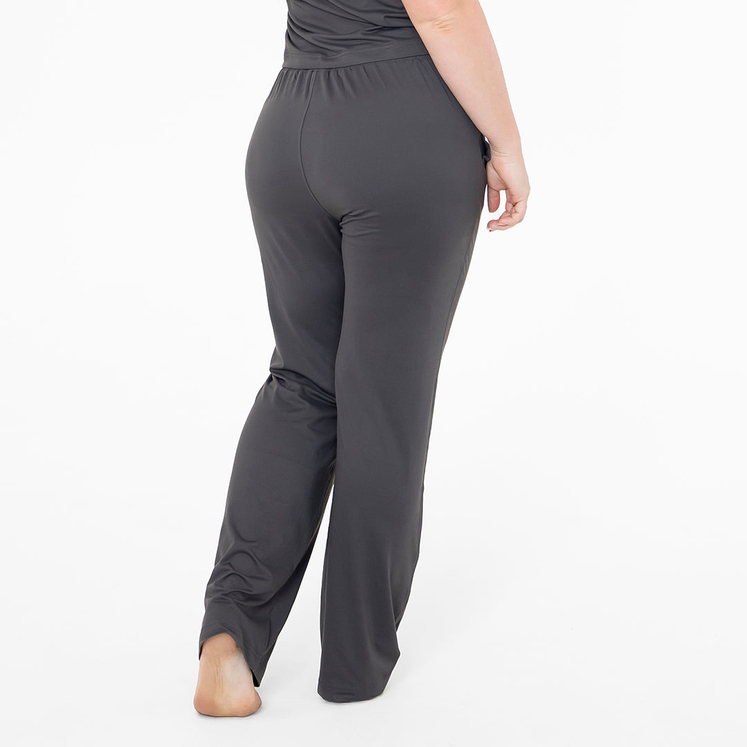 Dark gray pants worn by a person on a white background