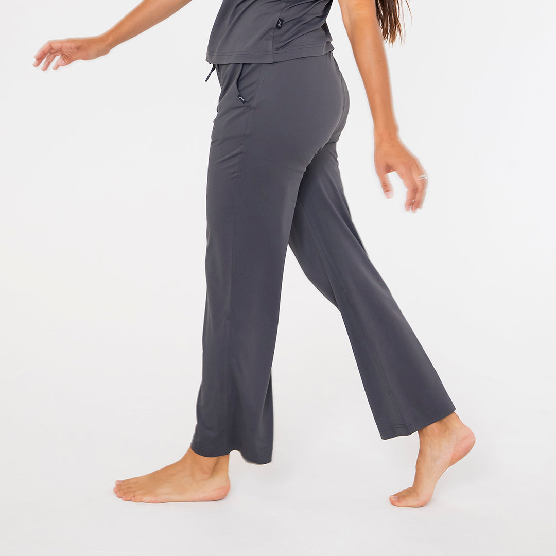 Person wearing gray pajama pants on a white background