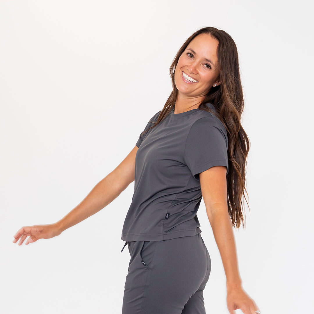 Woman wearing a gray athletic outfit on a white background