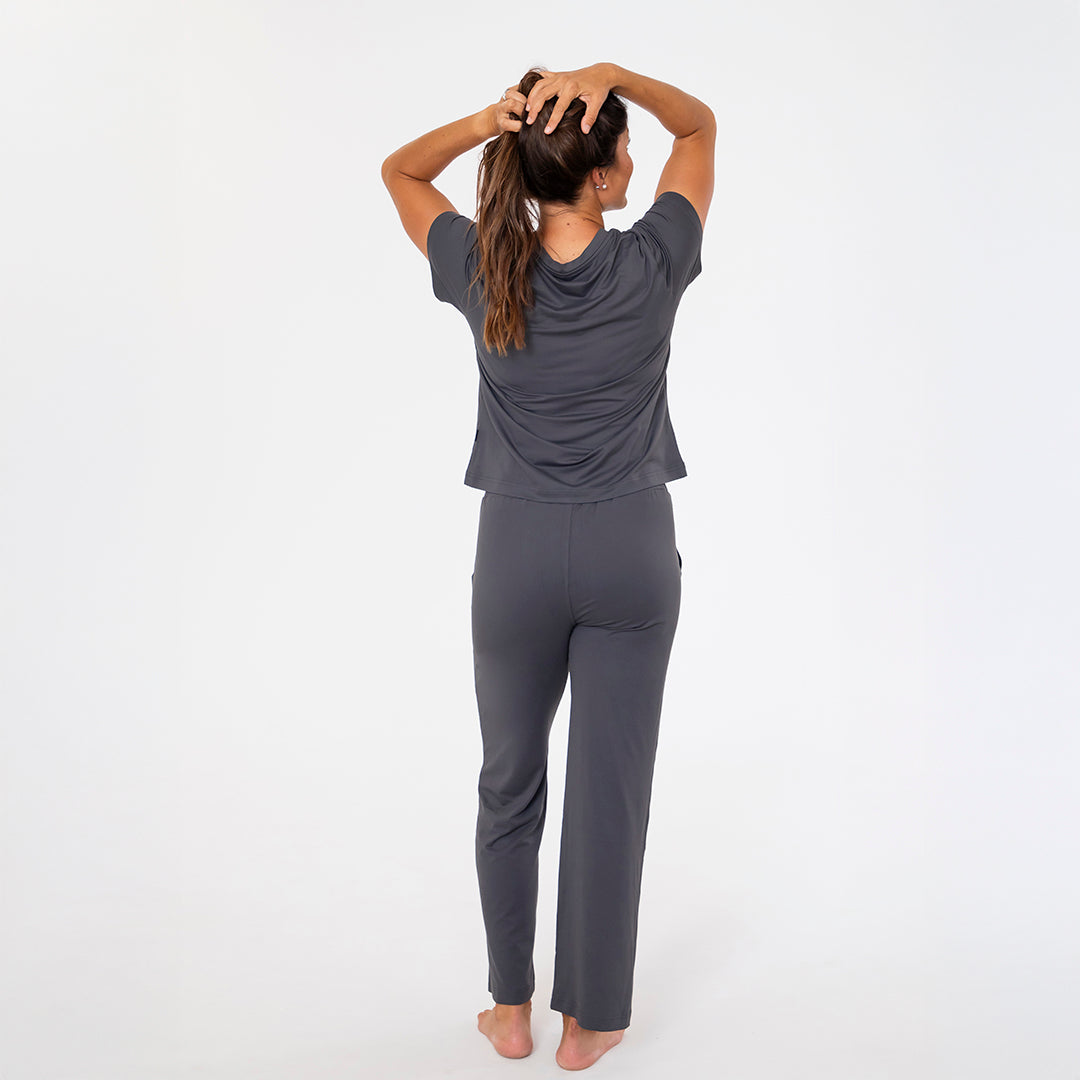 Person wearing a gray outfit on a white background