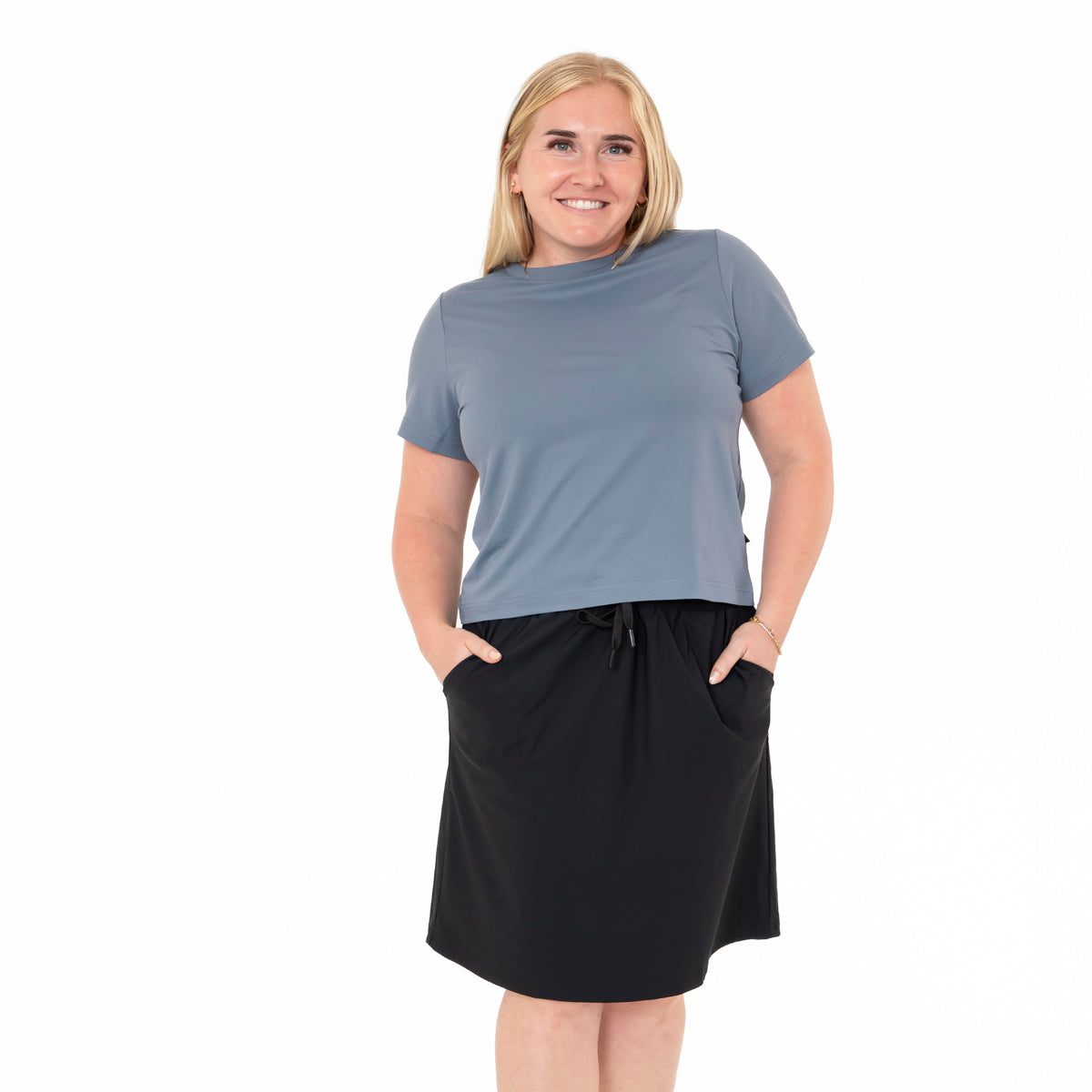 Woman wearing a gray t-shirt and black skirt on a white background