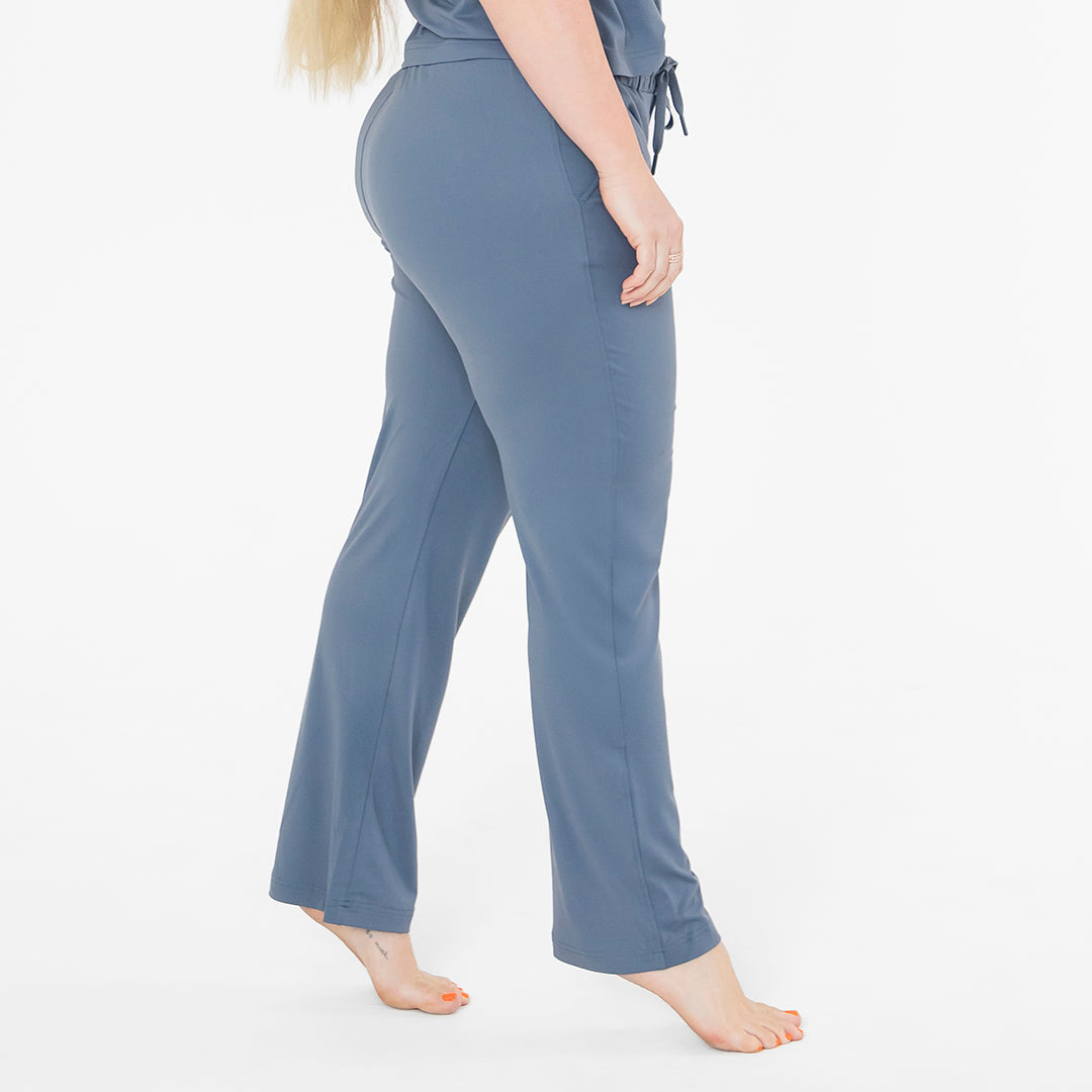 Woman wearing blue pajama pants on a white background