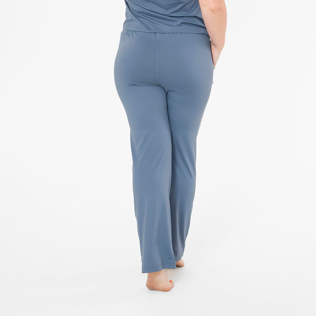 Person wearing blue pajama pants on a white background