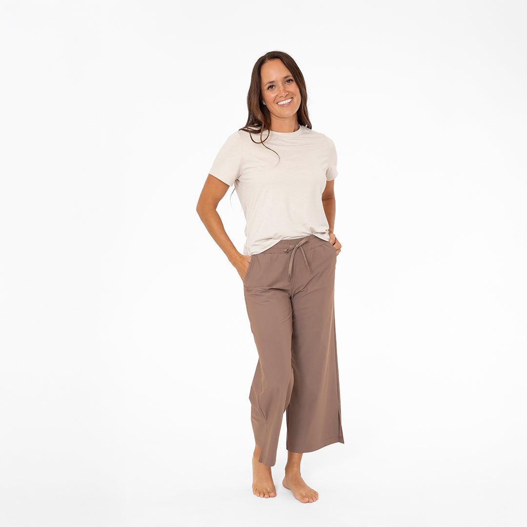 Woman wearing a white t-shirt and brown pants on a white background