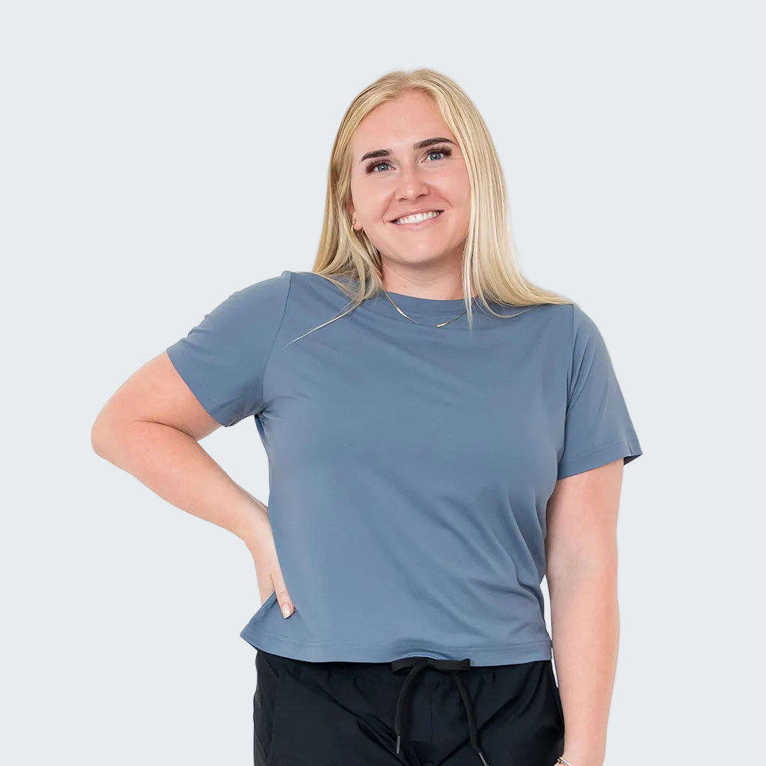 Woman wearing a blue t-shirt and black pants on a white background