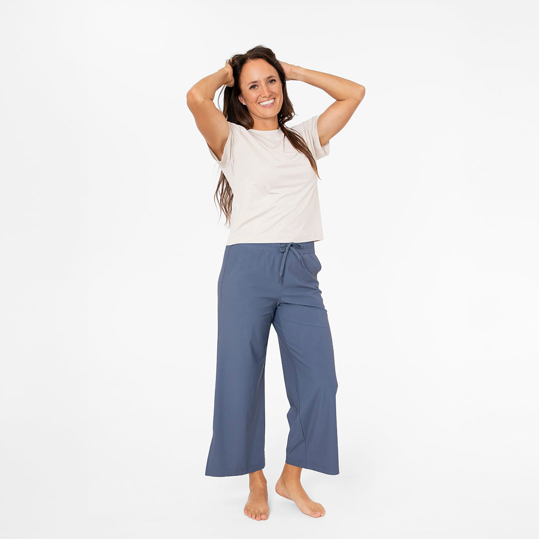 Woman wearing a white t-shirt and blue pants on a white background