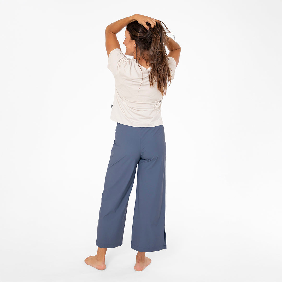 Person wearing a white top and blue pants on a white background