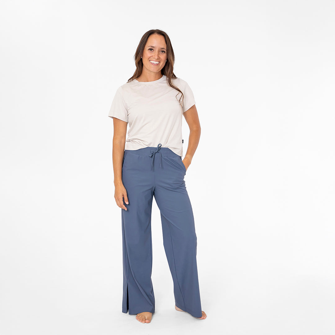 Woman wearing a white t-shirt and blue pants on a white background