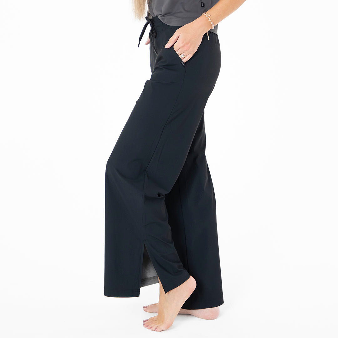 Person wearing black wide-leg pants on a white background