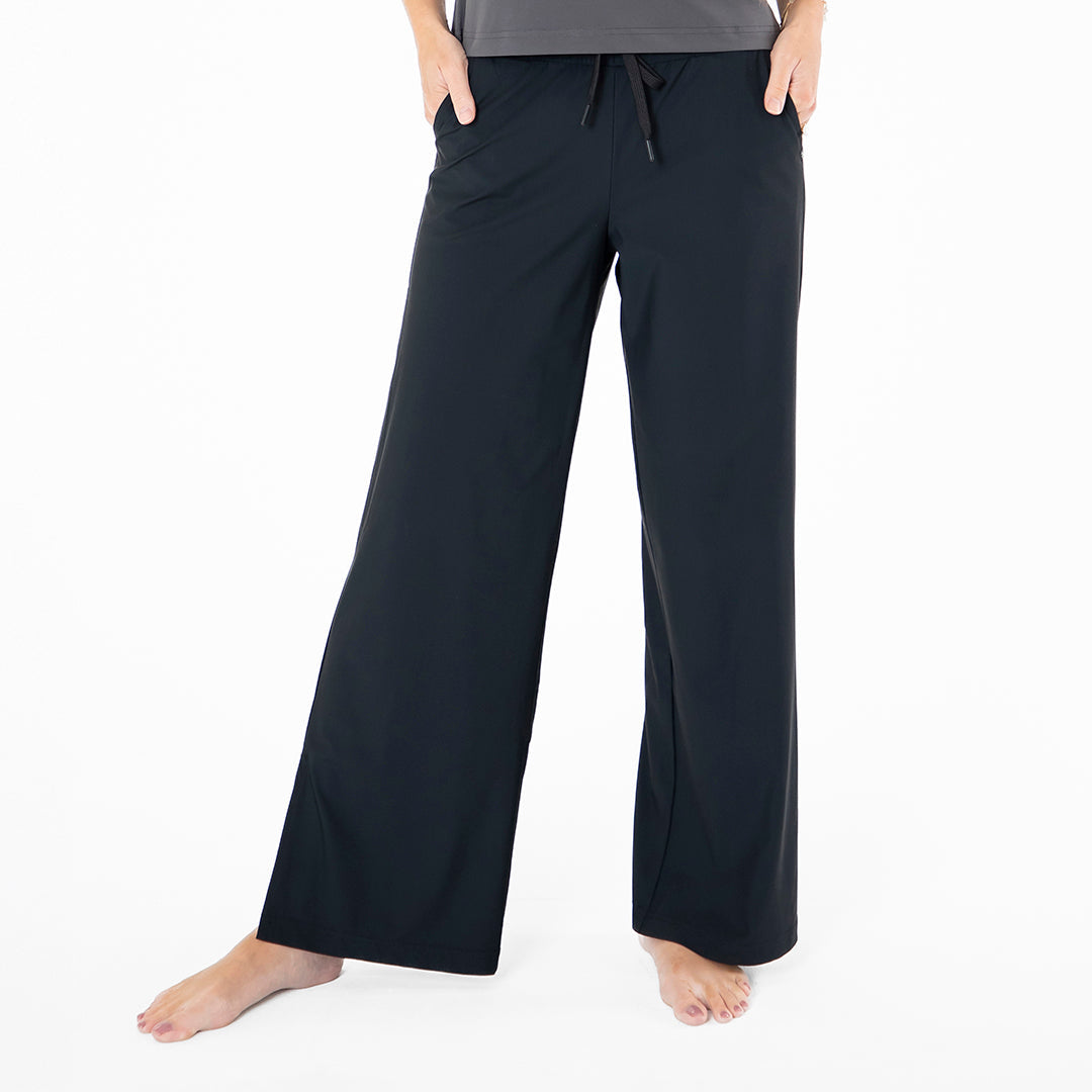 Black pajama pants worn by a person on a white background