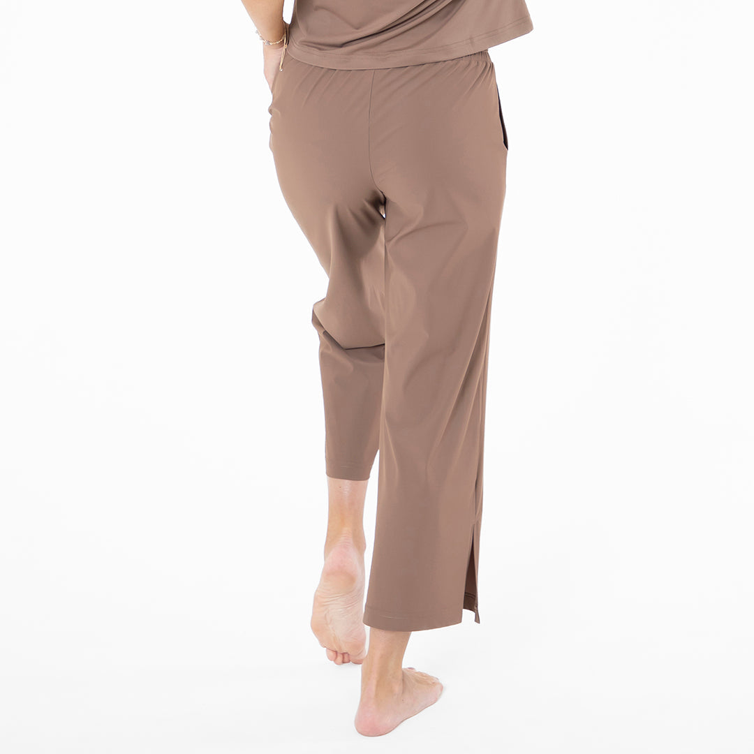 Brown pants worn by a person on a white background
