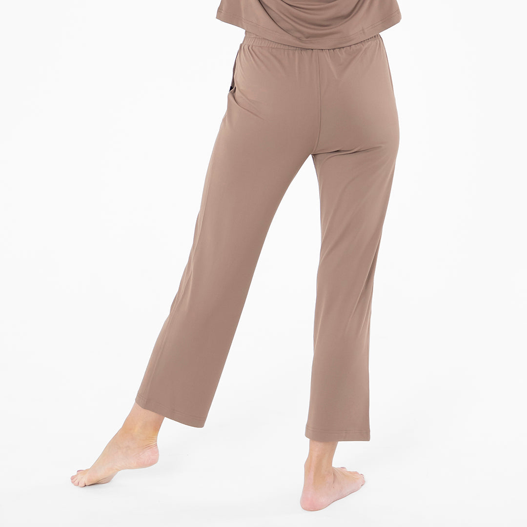 Brown pants worn by a person on a white background