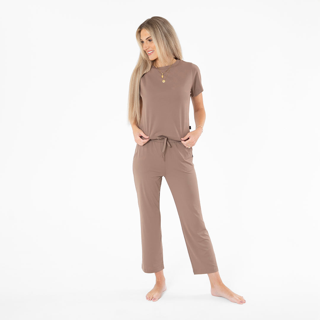 Woman wearing a brown pajama set on a white background
