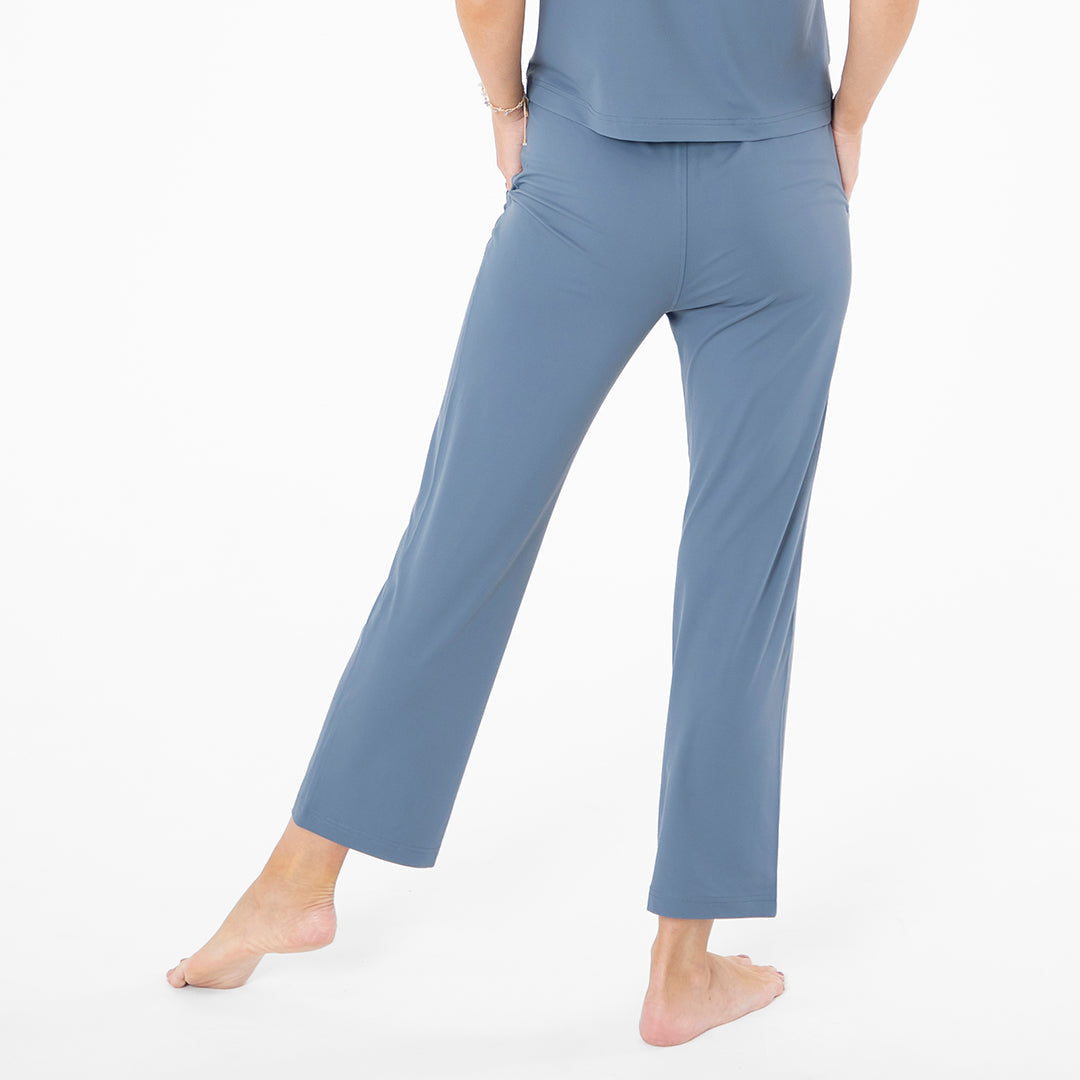 Person wearing blue pajama pants on a white background