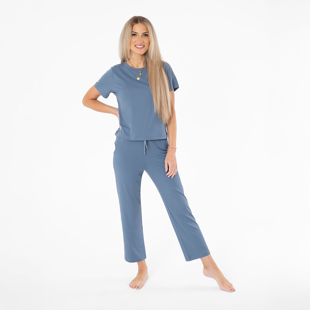 Woman wearing a blue pajama set on a white background