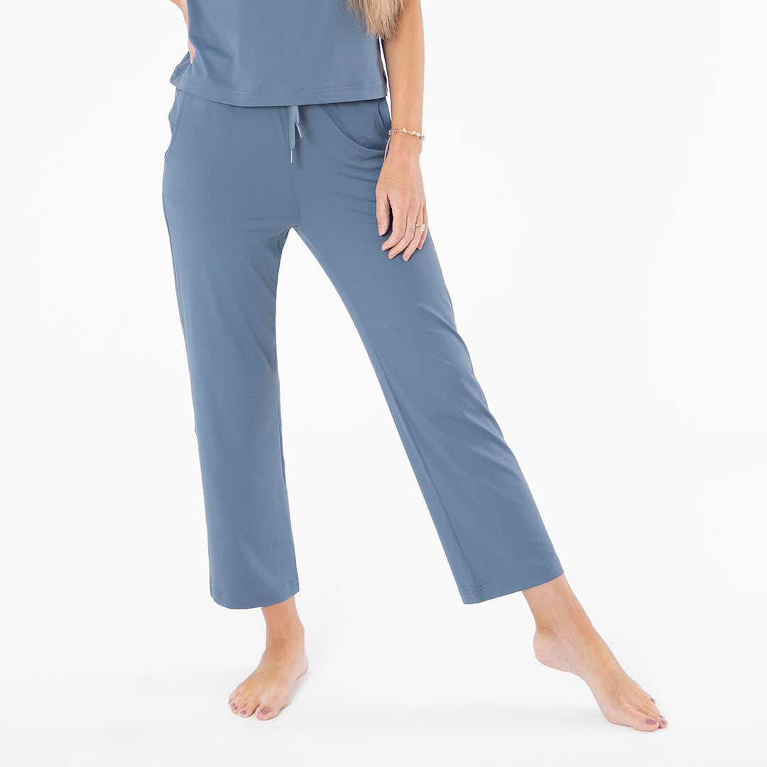 Person wearing blue pajama pants on a white background