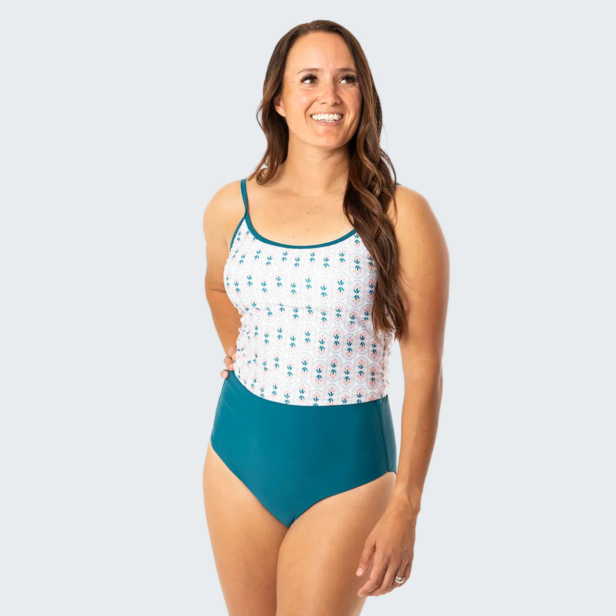 Woman wearing a white swimsuit with blue accents on a white background