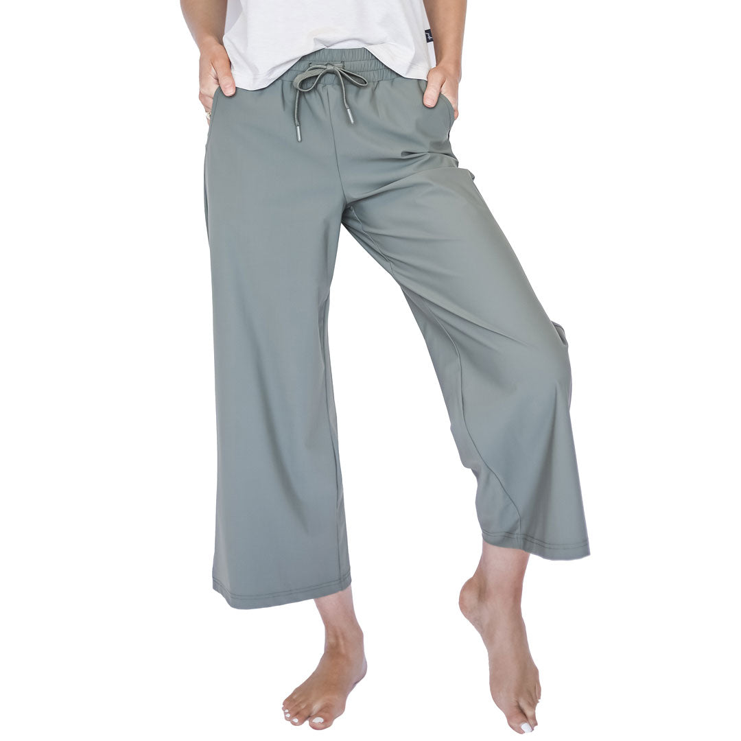 Person wearing light gray capri pants on a white background