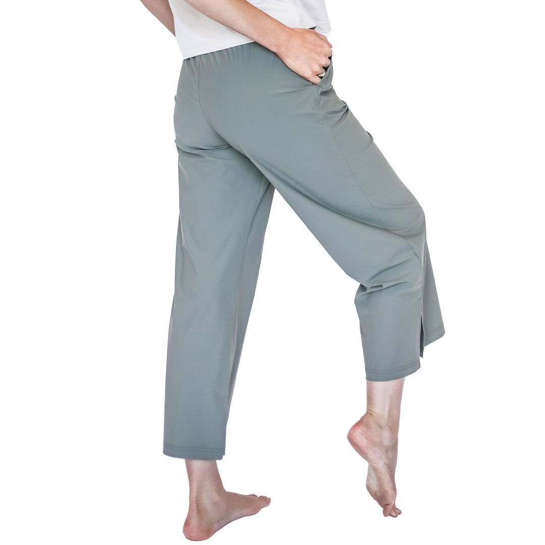 Person wearing light gray capri pants on a white background