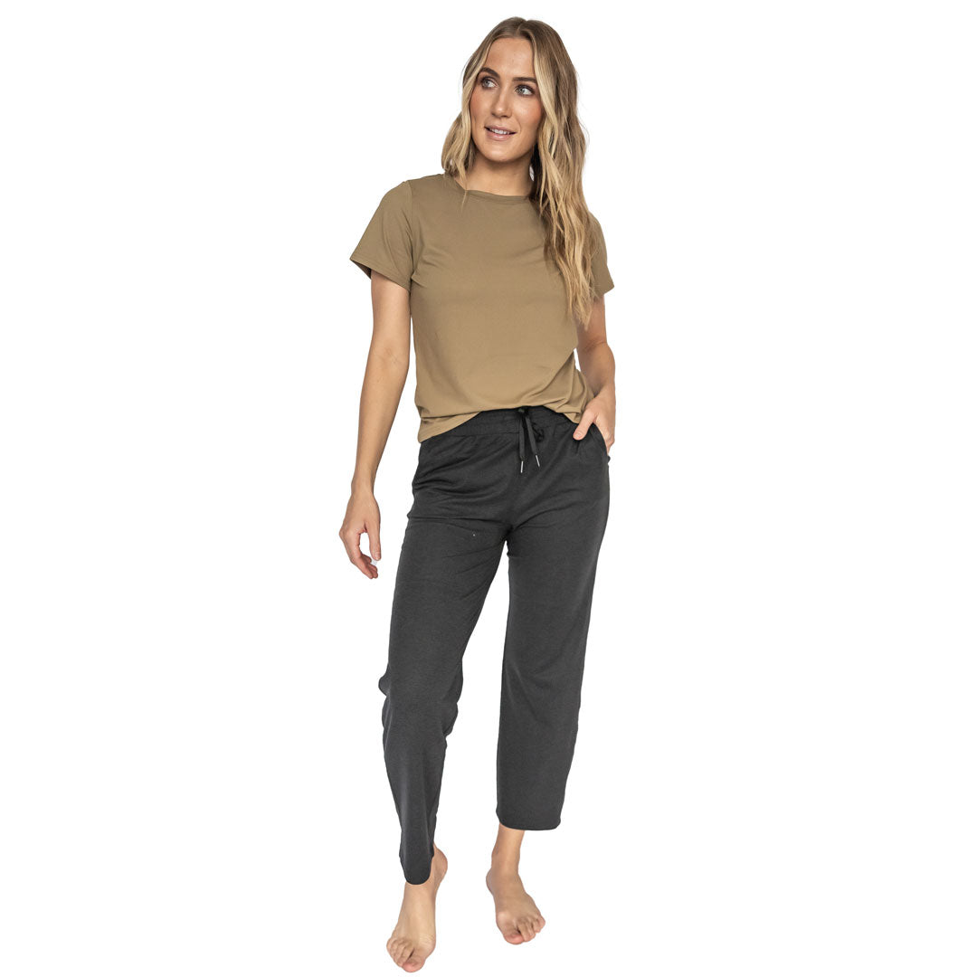Woman wearing a brown t-shirt and black pants on a white background