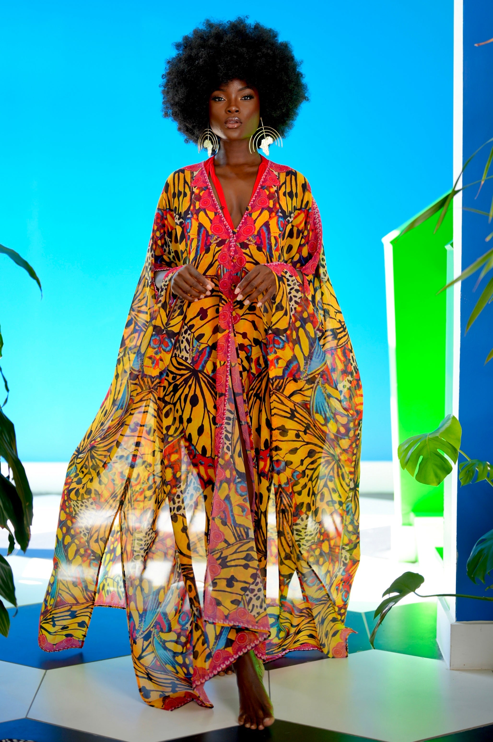 Woman wearing a colorful patterned outfit with a blue and green abstract background