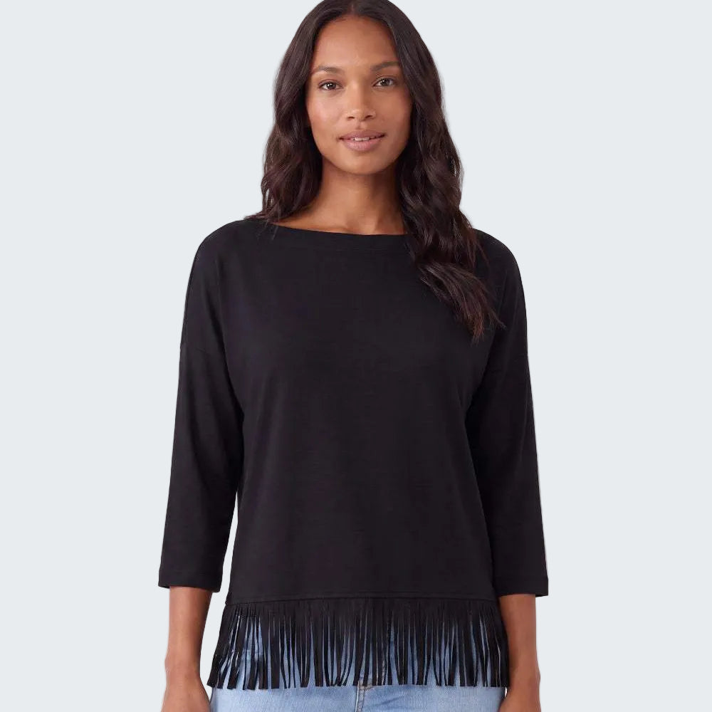 A woman modeling a black three-quarter sleeve top with fringe trim at the hem, paired with light blue jeans, against a plain white studio background.