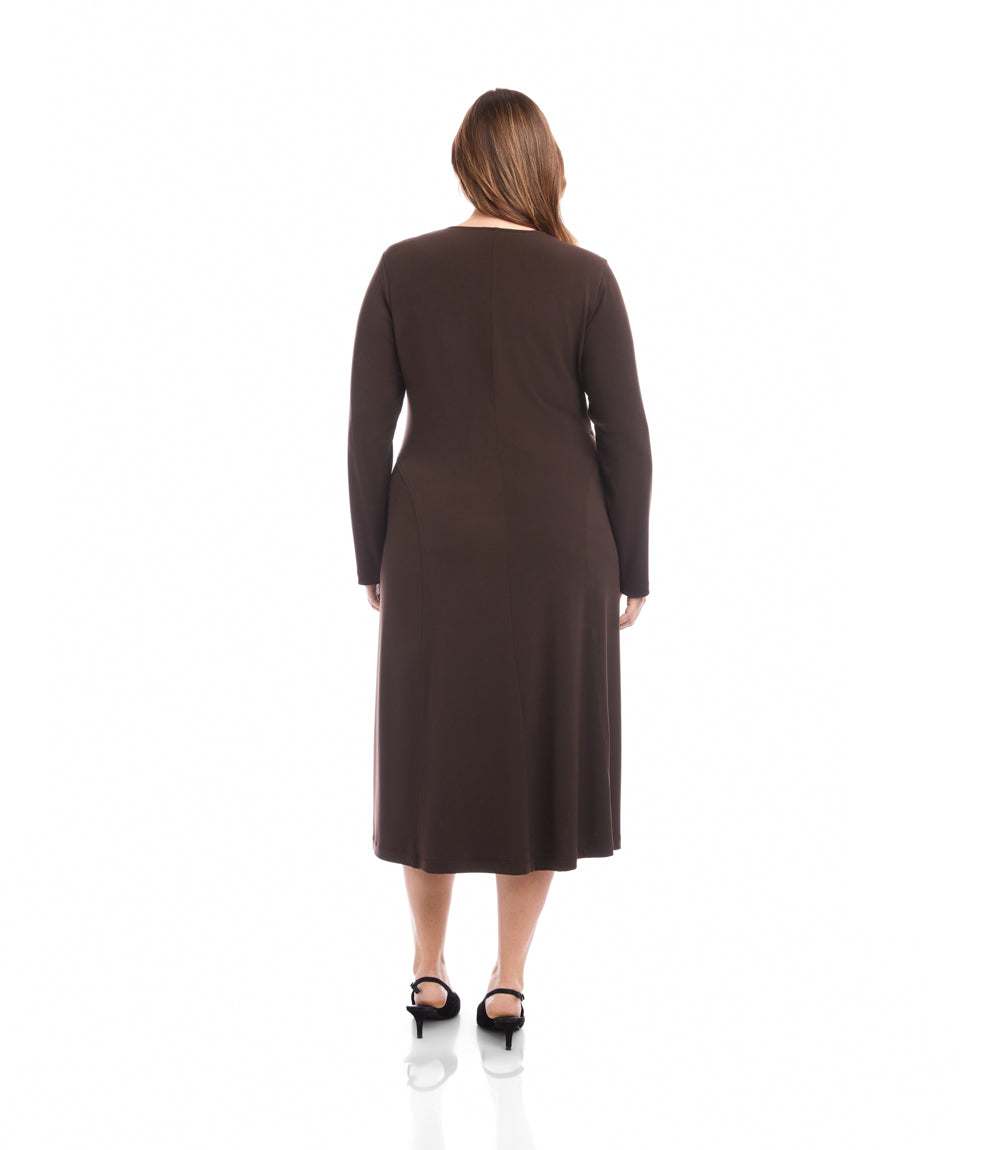 A woman viewed from the back wearing a dark brown long-sleeve midi dress and black heels, standing against a plain white studio background.